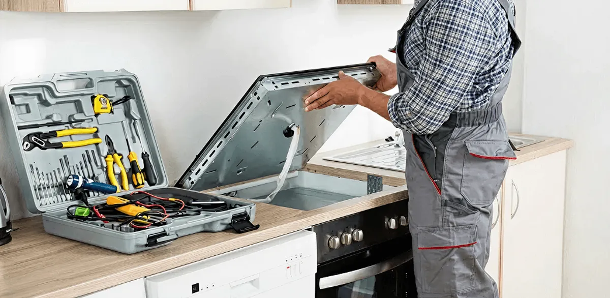 Handyman repairing a cooktop and checking wiring connections in Peoria, IL