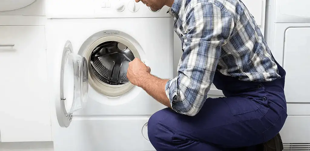 Handyman inspecting a dryer drum and internal parts for repair in Peoria, IL