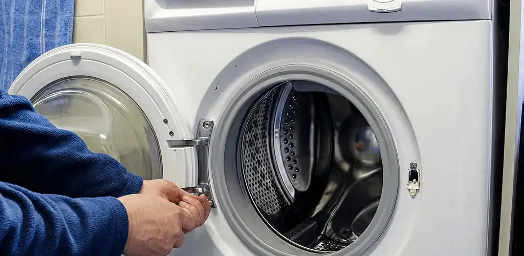 Washing machine repair handyman checking a front-load washer door and latch in Peoria, IL