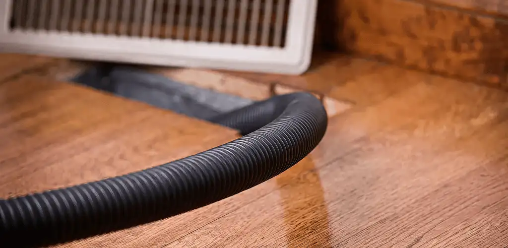 Air duct cleaning hose inserted into a floor vent for ductwork cleaning in Peoria, IL