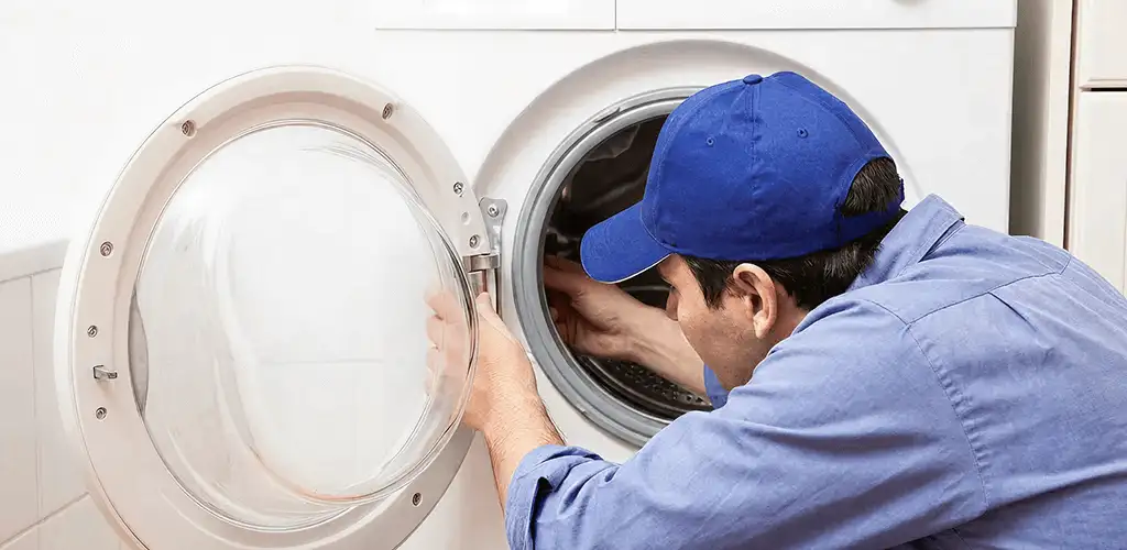 Washing machine repair handyman inspecting a front-load washer drum in Peoria, IL